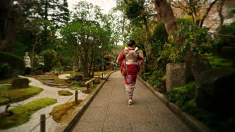 woman in kimono walking through a japanese garden