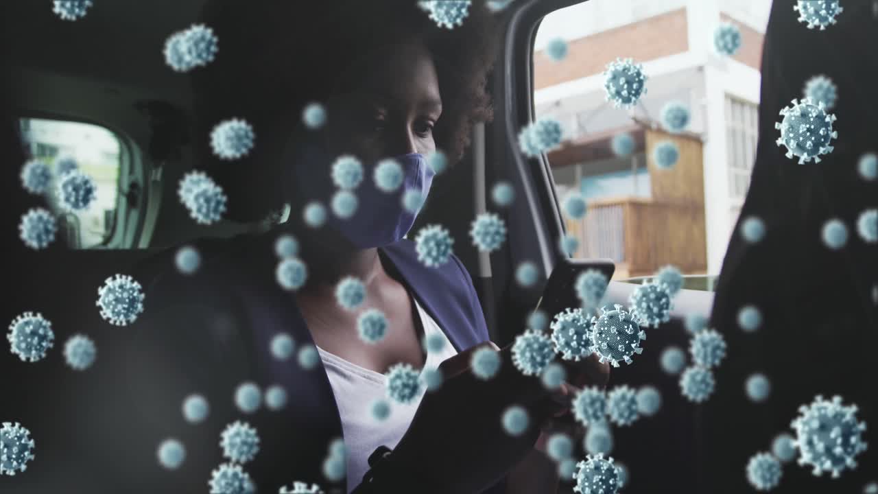 animación de células de coronavirus sobre una mujer afroamericana con máscara facial usando un teléfono inteligente en el coche
