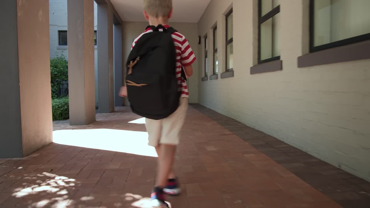 Bambino cammina lungo un sentiero ombreggiato, una zona illuminata dal sole provoca calci giocosi e si dirige verso il giardino