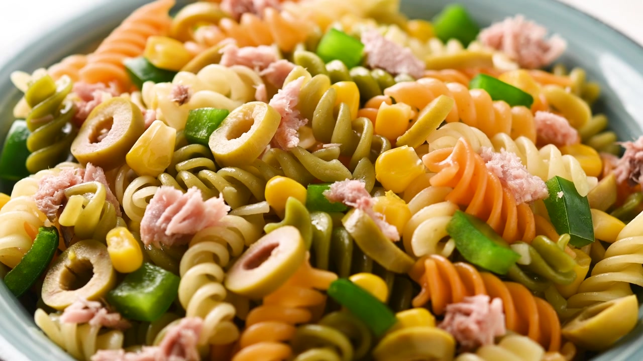 Pasta salad with tuna, corn and olives in bowl