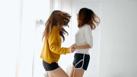 una joven pareja de lesbianas asiáticas bailando en el dormitorio. concepto de amistad de estilo de vida.