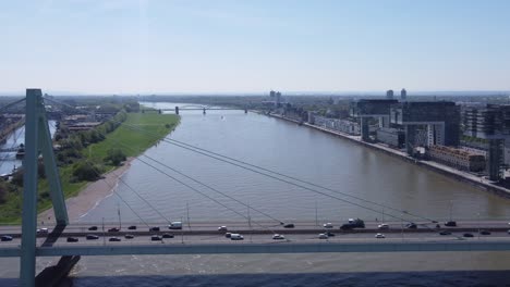 city traffic on severin bridge of cologne germany at rush hour and cars crossing rhine river, crane house buildings in background