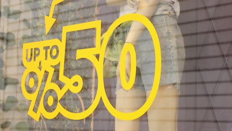 una vitrina de una tienda con un letrero de venta que dice hasta un 50% de descuento