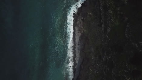 capture the beauty of turquoise waves crashing onto the shore and a mountain view with drone footage