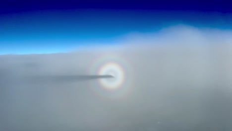 awesome view of the halo of a jet and shadow flying in a layer of thin stratus during cruise level at 12000 metres high