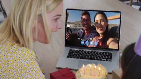 caucasian mother and daughter celebrating birthday on video call on laptop at home