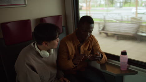 friends watching videos in the train