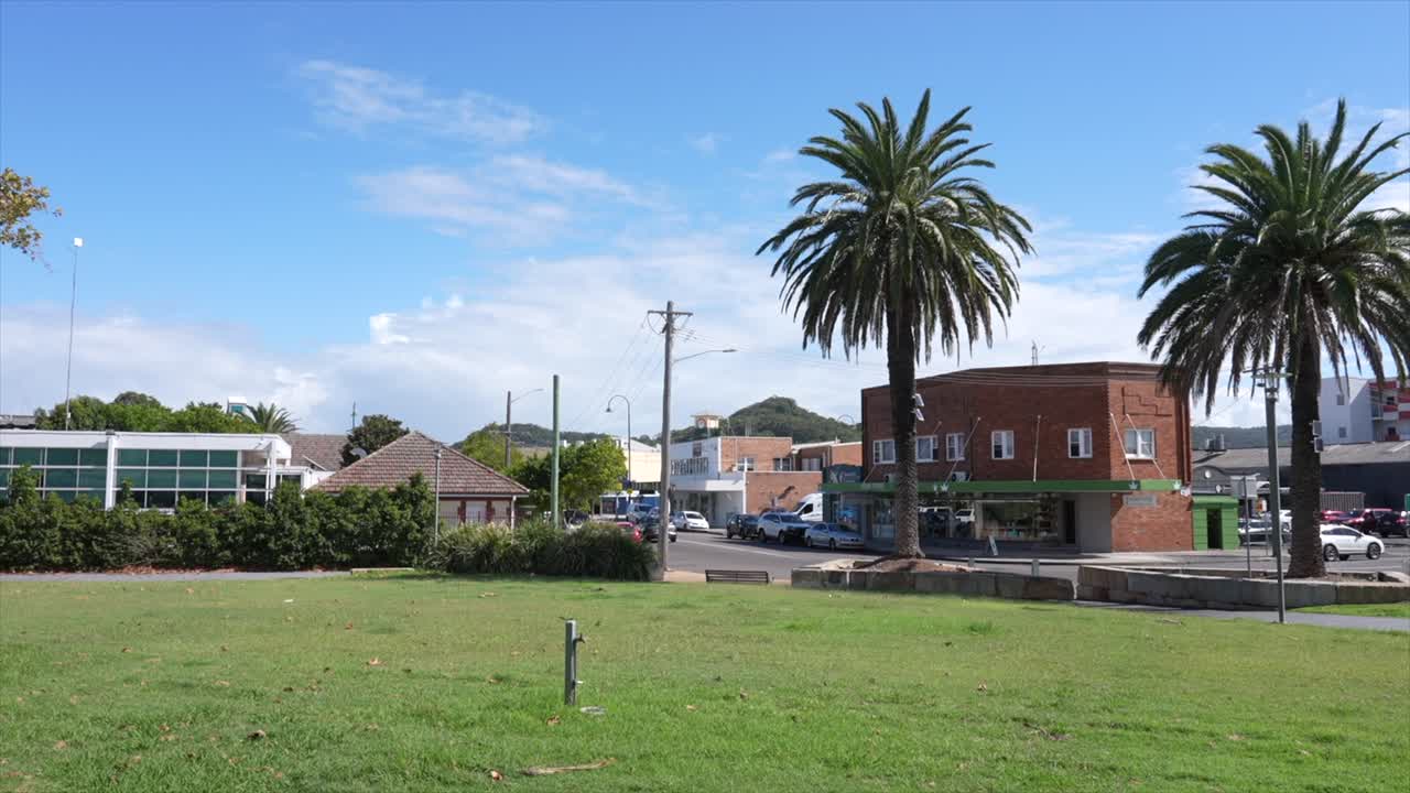 Parque con zona de césped y edificios de la ciudad al fondo, Woy Woy, Nueva Gales del Sur, Australia.