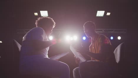 students preparing before a high school performance in an empty school theater