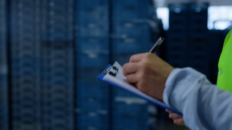 warehouse worker making notes collecting information analysing shipment process