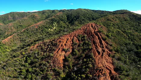 aerial view of a mountainous region with red dirt and lush green forests