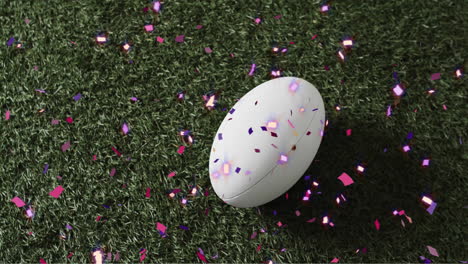 Animation-of-confetti-over-white-rugby-ball-on-grass