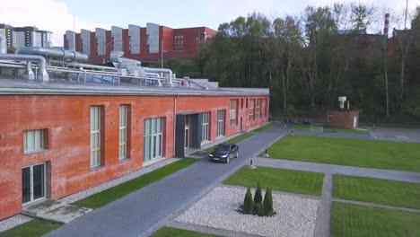 modern brick building with landscaping and a car