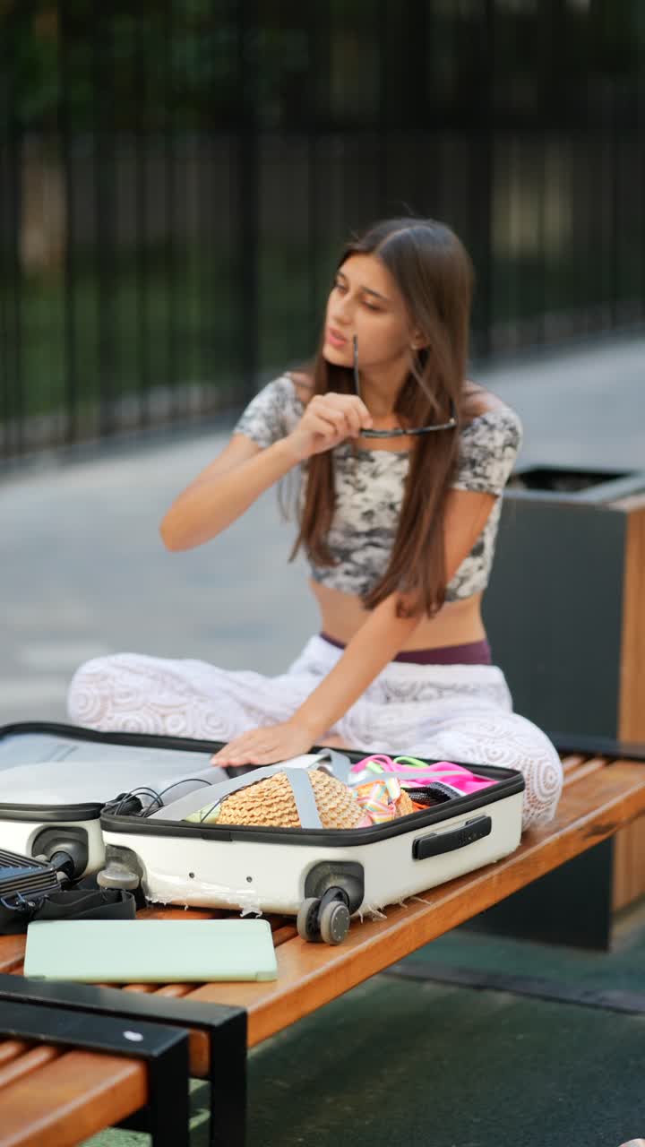 mujer preparándose para las vacaciones, sorprendida y cansada, sentada en un banco afuera