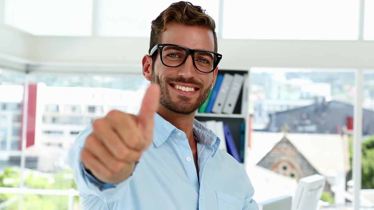 diseñador feliz dando pulgares hacia arriba a la cámara