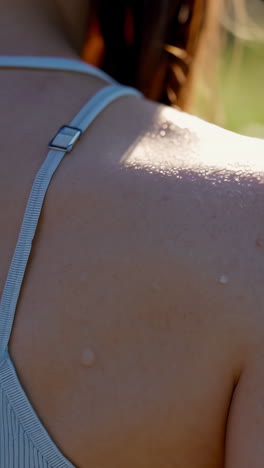 close-up of a person's shoulder glistening with water droplets in sunlight
