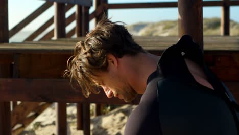 surfista masculino con traje de neopreno en la playa 4k