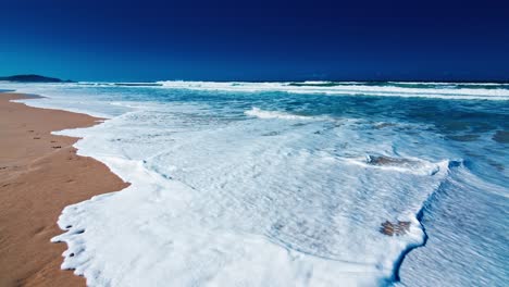 sandy beach with waves. beach with yellow sand and rolling gentle wave with foam. atlantic ocean, town of campeche, brazil