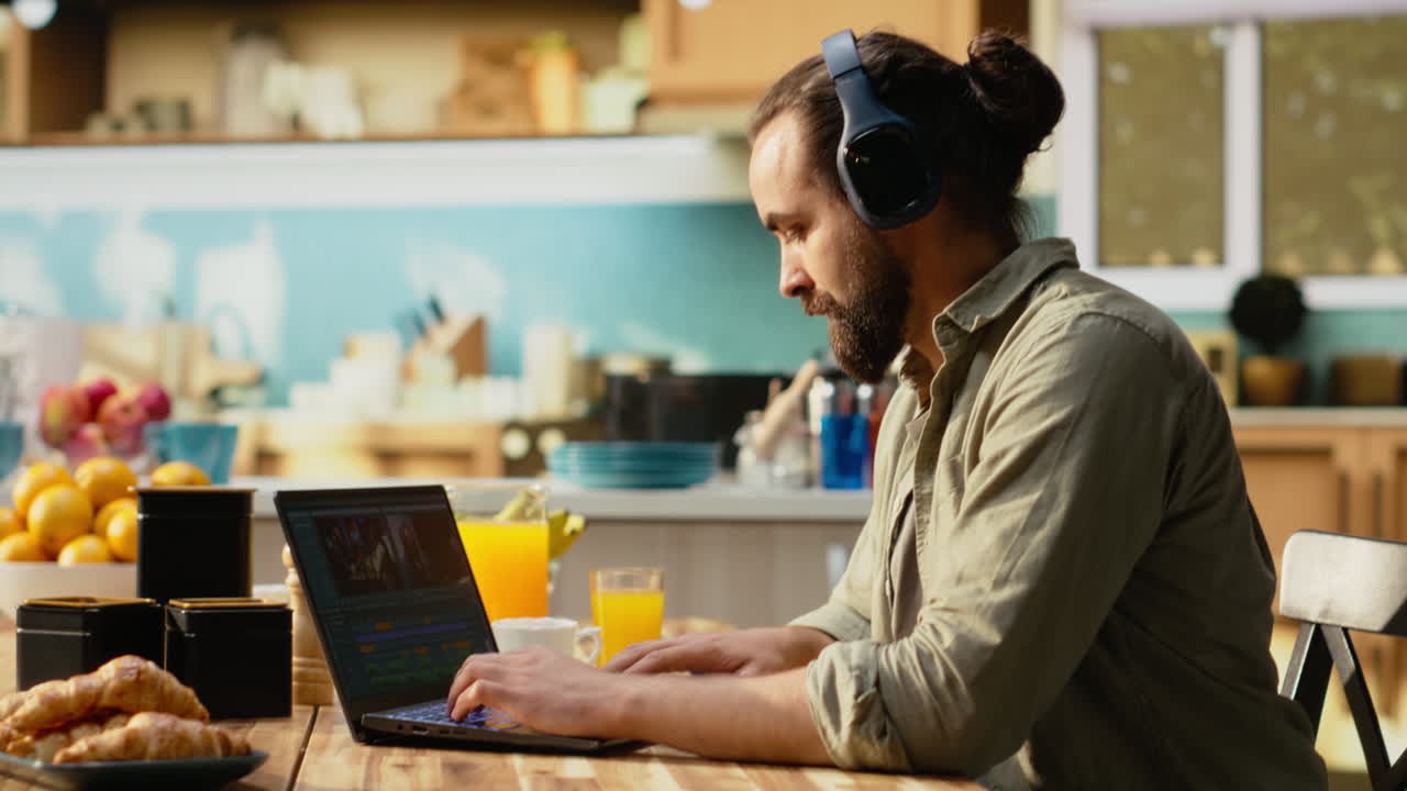Video editor, editing with headset, video content indoors, using a laptop