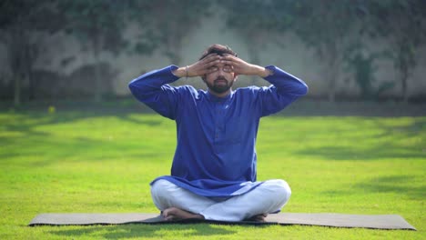 indian man doing breathing exercise