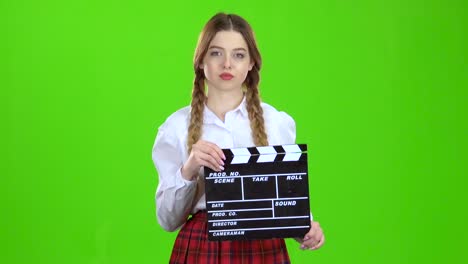 teenager with clapperboard on green screen