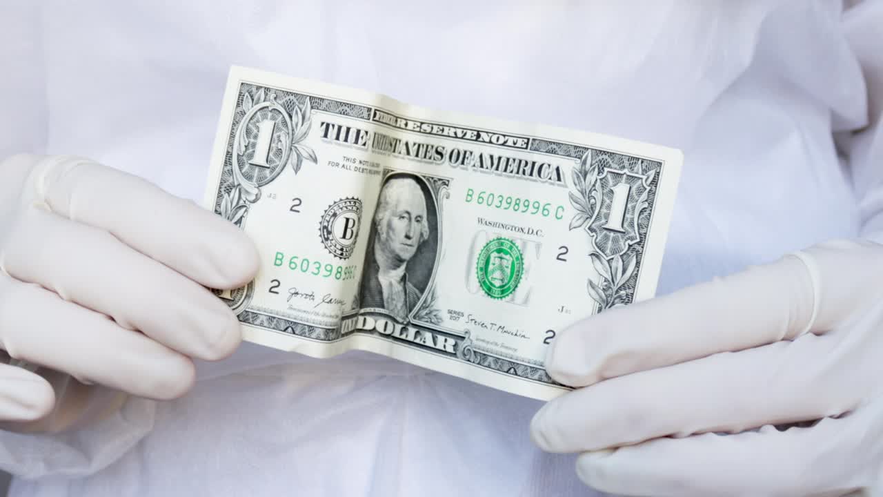 간호사 나 의사 는 양 손 에 1 달러 지폐 를 들고 있다