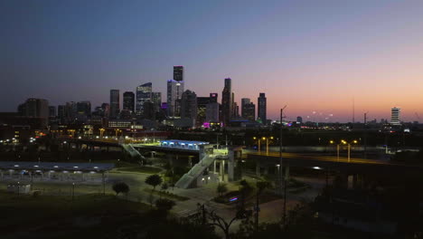 establishing drone shot approaching the main st w station, vivid dawn in houston
