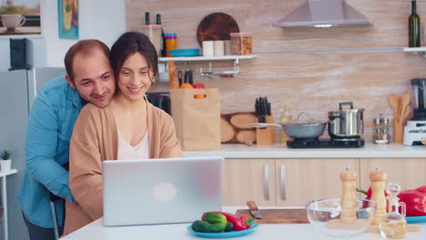 mujer usando laptop en la cocina