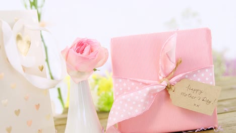 gift bag, gift box and flower vase on wooden surface