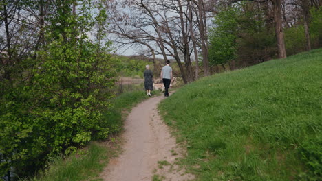 couple walking a path in a park by a lake