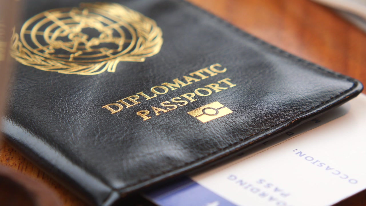 Hand Picking Up a Diplomatic Passport and Boarding Pass