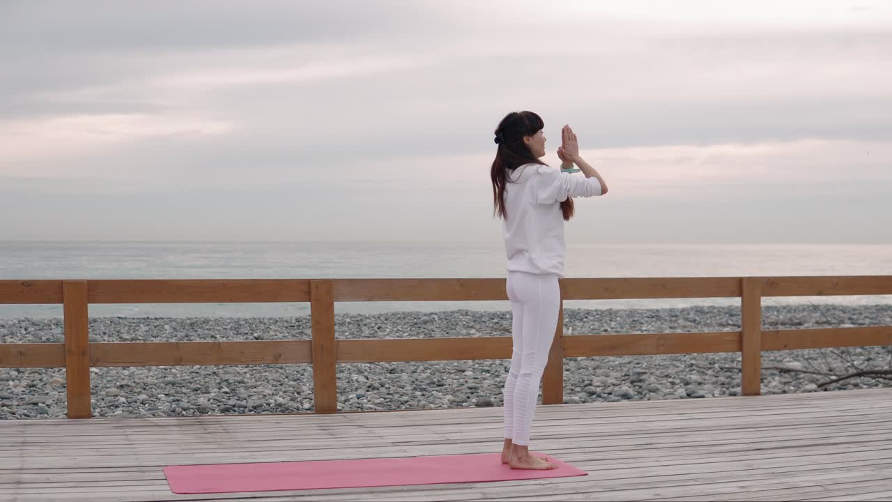 해변 산책로 에서 요가 를 연습 하는 여자