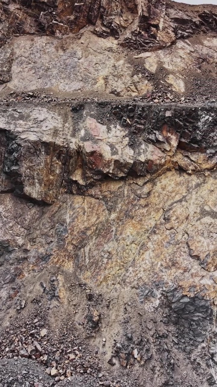 Parete rocciosa in una cava con texture ruvide e superfici irregolari