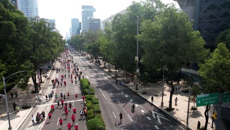 Rückwärts-Drohnenaufnahme-Von-City-Marathonläufern,-Die-Durch-Die-Innenstadt-Fahren