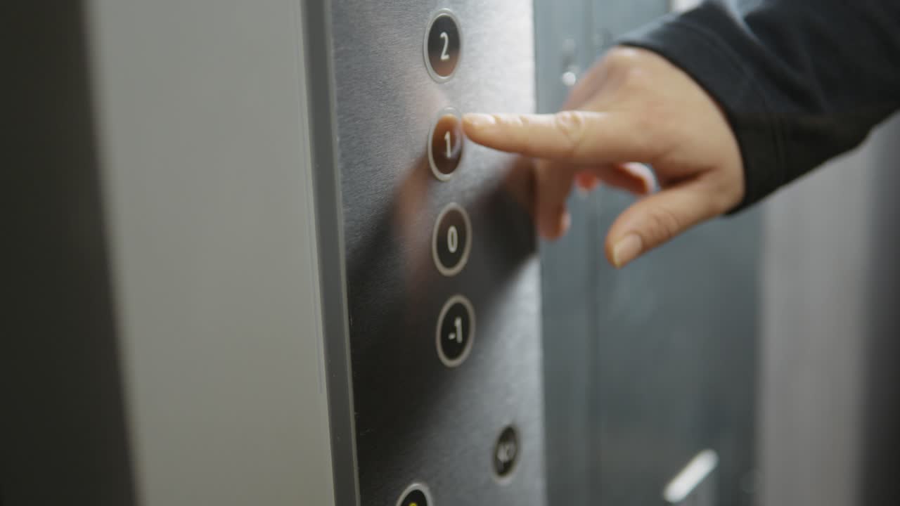 An elevator button is being pressed.