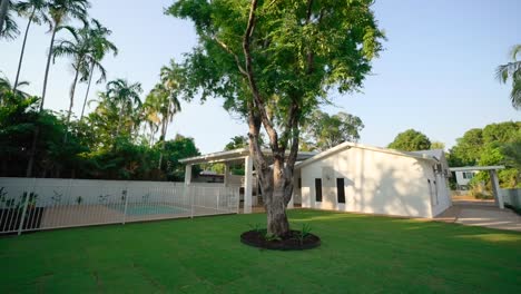 Exterior of a small luxury home with a large tree in the backyard, providing a peaceful outdoor space. Exterior of house home staged for real estate.