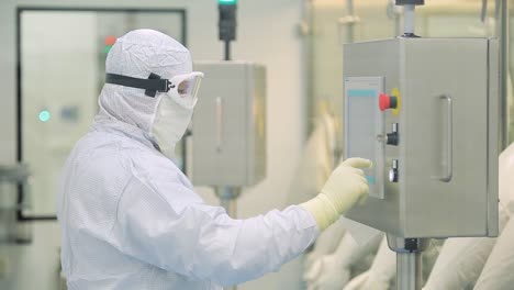 trabajador que opera el panel de control en una instalación de fabricación farmacéutica