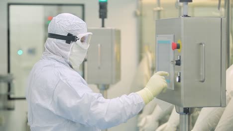 worker operating control panel in pharmaceutical manufacturing facility