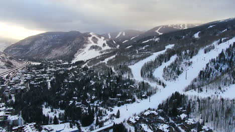 Aerial-Cinematic-Drone-Vail-Village-Vail-ski-resort-Lions-Head-early-morning-mid-winter-sunrise-of-ski-trails-and-gondola-scenic-mountain-landscape-of-Colorado-forward-reveal-pan-up-movement