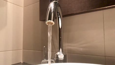Closeup-of-single-handle-disk-faucet-with-constant-running-water