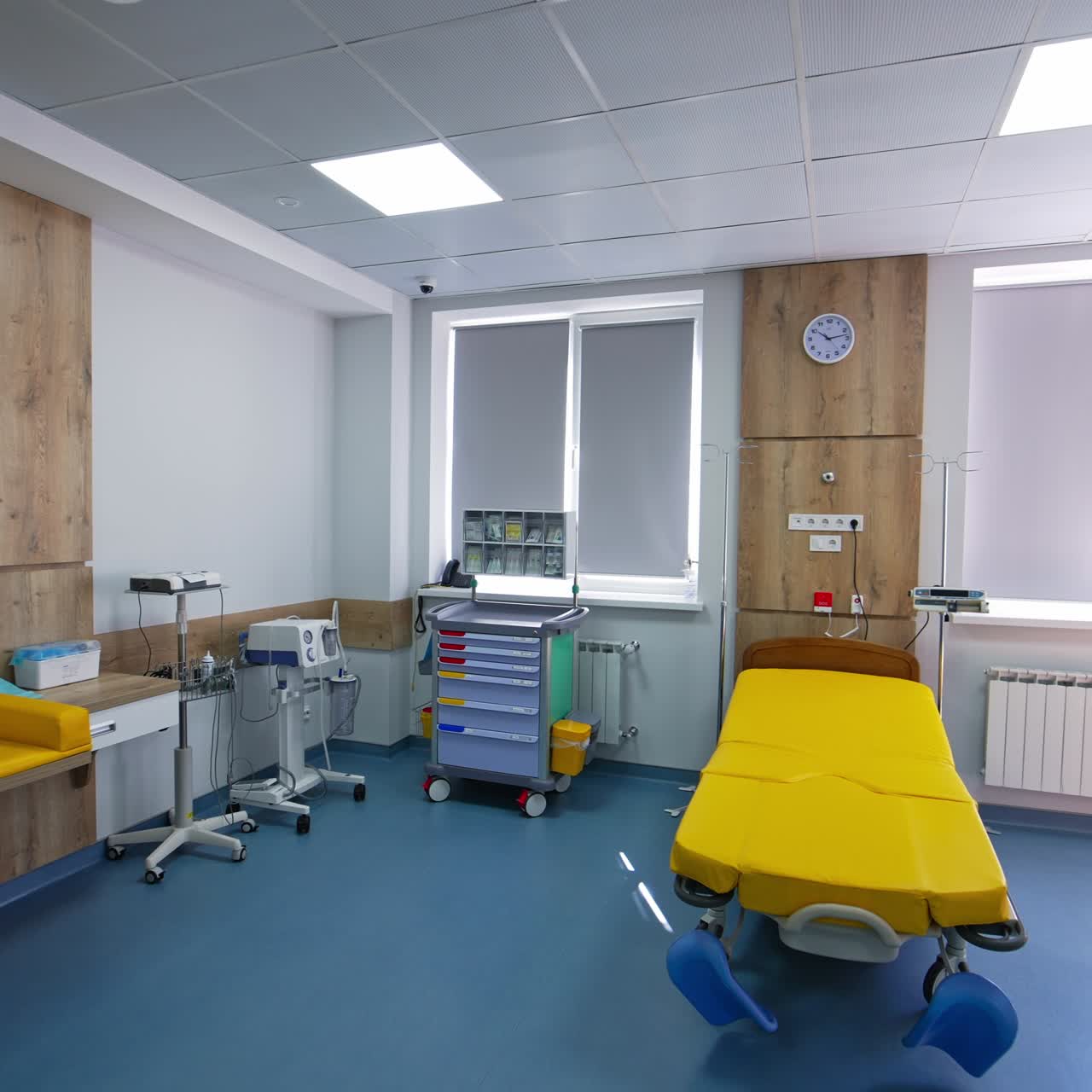Diverse equipment on the wheels standing in the corner of delivery room. Spacious ward in modern maternity hospital