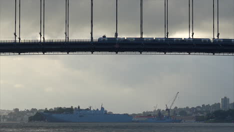 Un-Tren-De-Sydney-Pasa-Por-El-Puente-Del-Puerto-Con-El-Agua-Debajo