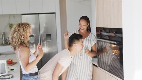 Un-Joven-Asiático-Y-Una-Mujer-Birracial-Comparten-Una-Risa-En-Una-Cocina-Moderna-Mientras-Preparan-Pizza