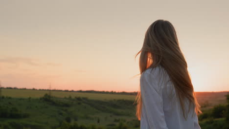 Teenager-Mädchen-Dreht-Bei-Sonnenuntergang-Ihren-Kopf-Und-Ihre-Langen-Haare.-Zeitlupenvideo