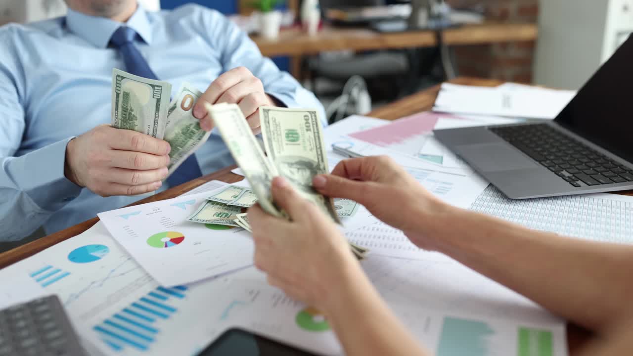 hombre de negocios y mujer sentados en la mesa y contando dinero primer plano película 4k en cámara lenta