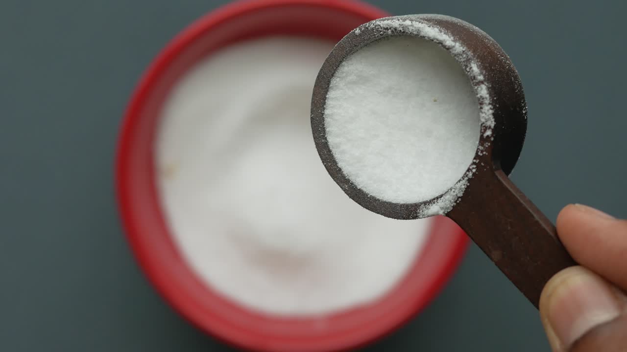 medición de polvo blanco con cuchara de madera