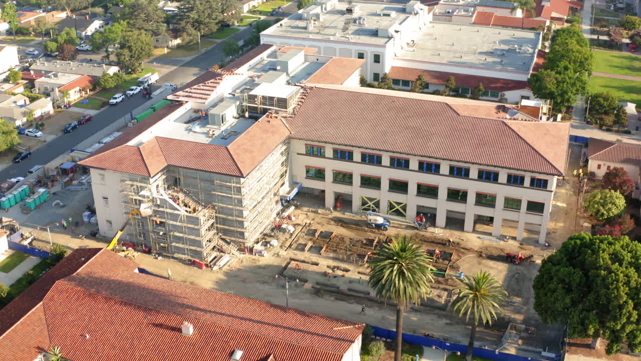 Aerial View of a Large Building Undergoing Construction with Scaffolding and Workers
