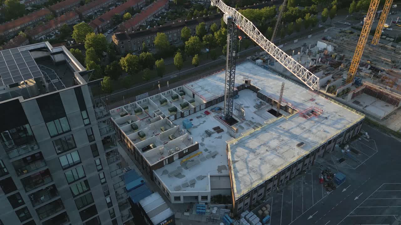 Drone footage of a large construction site with cranes and high-rise buildings under development in an urban area