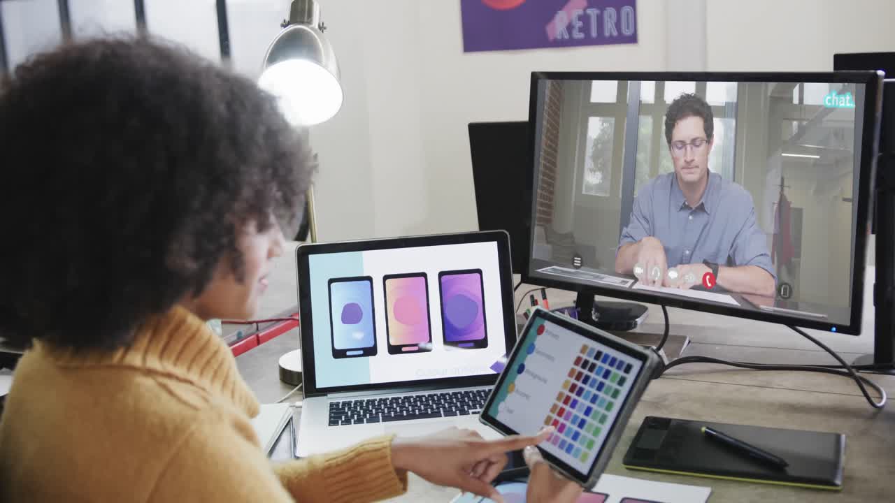 mujer de negocios afroamericana en videollamada con un colega caucásico en la pantalla