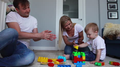 Glückliche-Familie,-Vater,-Mutter-Und-Baby-2-Jahre,-Die-In-Ihrem-Hellen-Wohnzimmer-Lego-Spielen.-Zeitlupenaufnahmen-Einer-Glücklichen-Familie